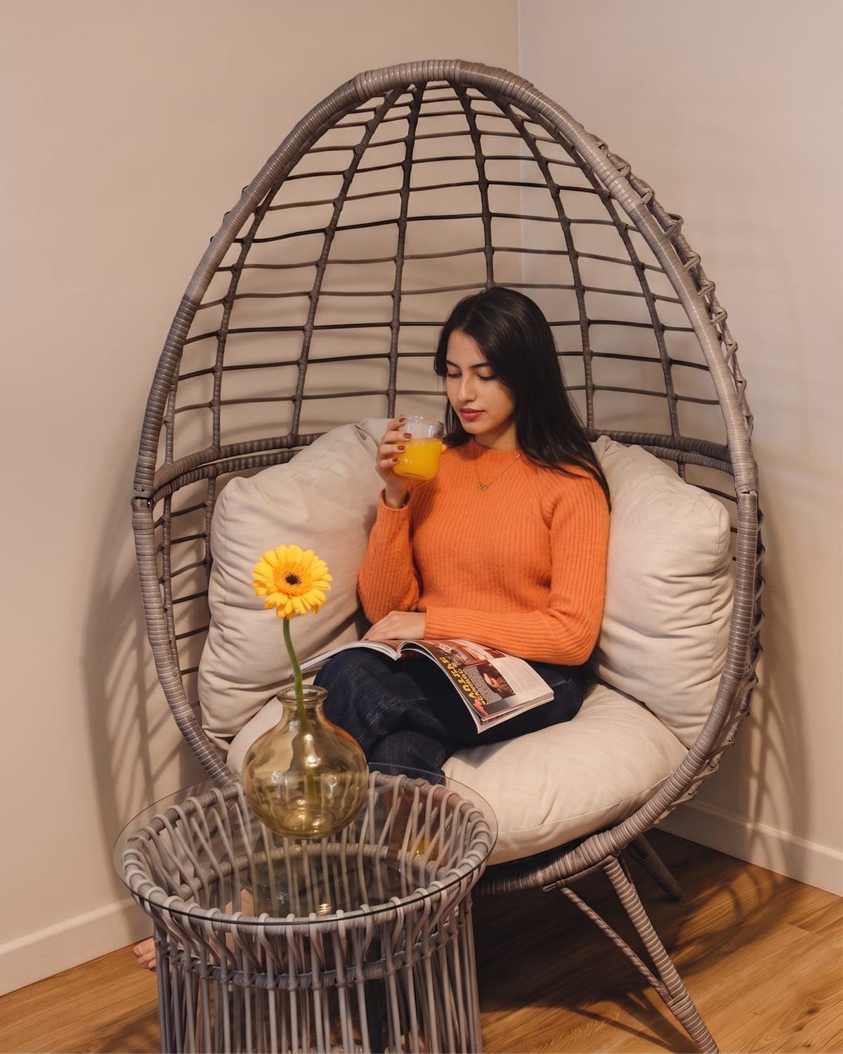 Relaxed guest in the hotel's cocoon chair, orange juice in hand