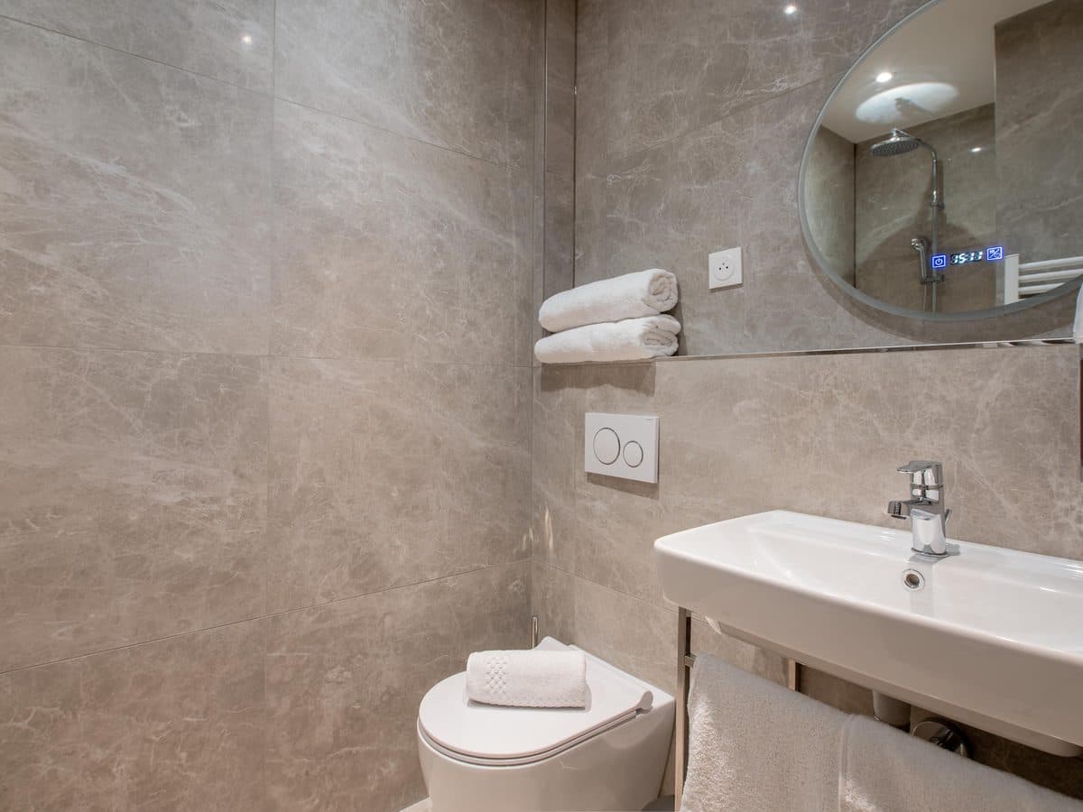 Salle de bain en marbre avec douche à l'italienne
